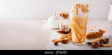 Kürbiskuchen-Milchshake mit Karamellsirup und Schlagsahne Stockfoto
