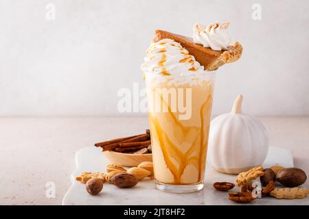 Kürbiskuchen-Milchshake mit Karamellsirup und Schlagsahne Stockfoto