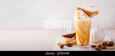 Kürbiskuchen-Milchshake mit Karamellsirup und Schlagsahne Stockfoto