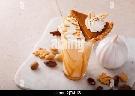 Kürbiskuchen-Milchshake mit Karamellsirup und Schlagsahne Stockfoto