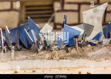 Wand mit scharfen Scherben zum Schutz vor Eindringlingen gekrönt Stockfoto