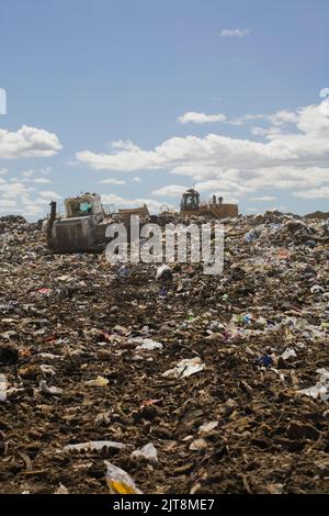 Bulldozer verteilen und verdichten weggeworfene Abfälle und Müll auf der Abfallbewirtschaftungsstelle in Quebec, Kanada Stockfoto