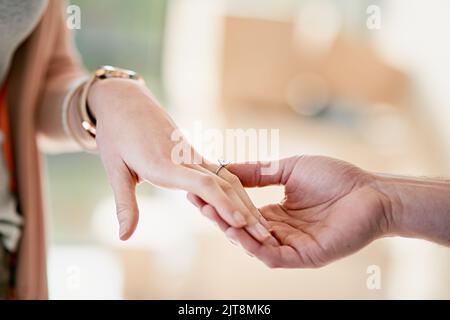 Gemeinsam für immer und ewig. Nahaufnahme eines Mannes, der einen Verlobungsring auf den Finger seiner Verlobten legt. Stockfoto