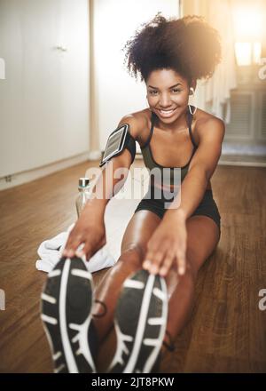 Gib alles, jeden Tag. Eine junge Frau macht Stretching-Übungen zu Hause. Stockfoto
