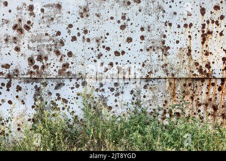 Charkiw, Ukraine. 30.. Juli 2022. Betonwand mit zahlreichen Spuren von Bruchstücken explodierender Muscheln. Auf den Straßen gibt es Krater von Granatexplosionen und ein umgedrehter, gesprengter Wagen. Die Straßen von Charkiw während des Krieges mit der Russischen Föderation. (Foto von Mykhaylo Palinchak/SOPA Images/Sipa USA) Quelle: SIPA USA/Alamy Live News Stockfoto