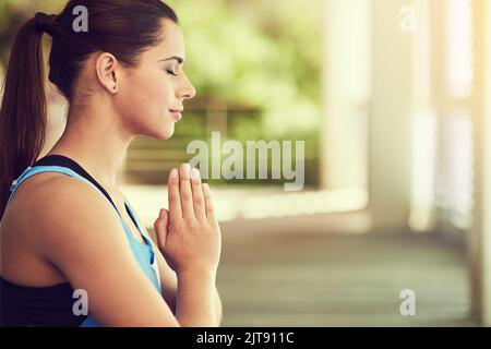 Finden Sie Frieden in allem, was Sie tun. Eine junge Frau praktiziert Yoga. Stockfoto