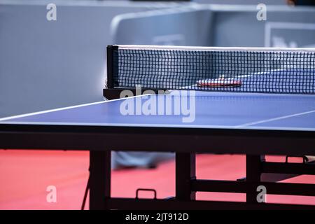 Blaue und glatte Oberfläche Tischtennisplatte mit engen schwarzen Netz, um für Training und Wettbewerb vorbereitet zu werden. Stockfoto