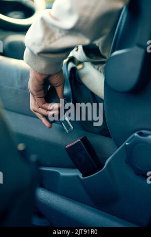 Sicherheit sollte Ihre oberste Priorität sein. Nahaufnahme eines nicht identifizierbaren Mannes, der seinen Sicherheitsgurt in einem Fahrzeug befestigt. Stockfoto