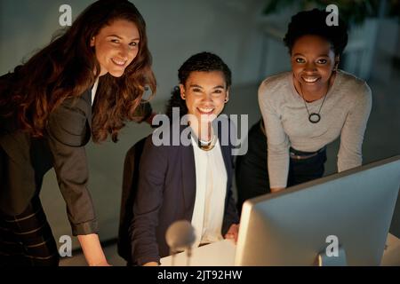 Das dynamische Trio. Porträt einer Gruppe von Kollegen, die spät in einem Büro arbeiten. Stockfoto