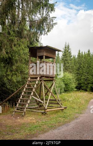 Hölzerner Huntsman hoher Sitz am Waldrand vor einer Wiese mit grünem Hintergrund Stockfoto