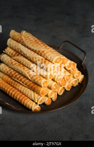 Rockige, knusprige Röhrchen mit Kondensmilch auf einem Metalltablett Stockfoto