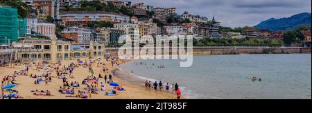 San Sebastian, Spanien - Juni 26 2021: Panoramablick auf die Bucht von La Concha und den Strand voller Menschen, die Küste und Hotels am Wasser, Baskenland Stockfoto