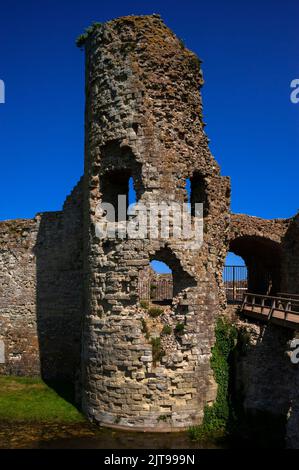 Der tiefblaue Himmel wurde durch klaffende Löcher im Torhaus-Turm aus dem 13.. Jahrhundert gesehen, der den Zugang zum inneren bailey of Pevensey Castle in East Sussex, England, Großbritannien, kontrollierte, das von den Normannen innerhalb der Mauern der spätrömischen Küstenfestung Anderitum erbaut wurde. Stockfoto