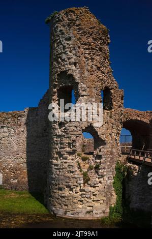 Wolkenloser, dunkelblauer Himmel, der durch klaffende Löcher im Torhaus-Turm aus dem 13.. Jahrhundert gesehen wurde, der den Zugang zum inneren bailey von Pevensey Castle in East Sussex, England, Großbritannien, kontrollierte, das von den Normannen innerhalb der Mauern der spätrömischen Küstenfestung Anderitum erbaut wurde. Stockfoto