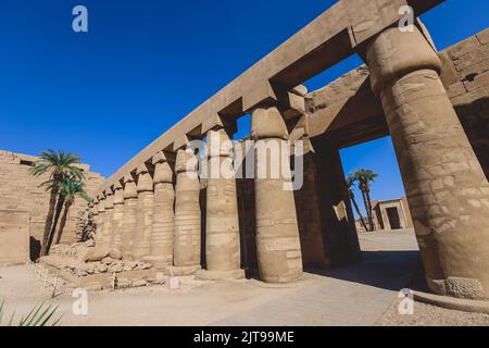 Luxor, Ägypten - 11. November 2020: Alte massive Säulen des Karnak-Tempelkomplexes in der Großen Hypostyle-Halle im Bezirk Amun-Re Stockfoto