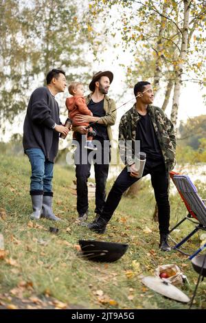 Multirassische männliche Freunde ruhen im Herbst in der Natur Stockfoto