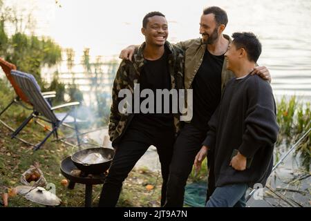 Drei multirassische männliche Freunde, die Spaß beim Angeln haben Stockfoto
