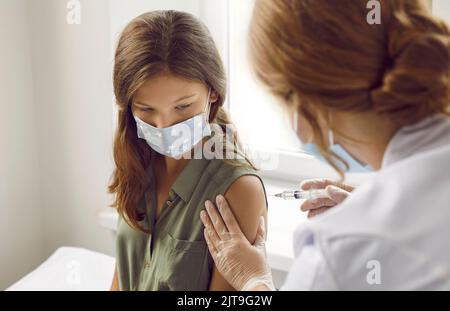 Das Mädchen erhält im Krankenhaus eine Injektion mit antiviralem Impfstoff gegen das Coronavirus. Stockfoto