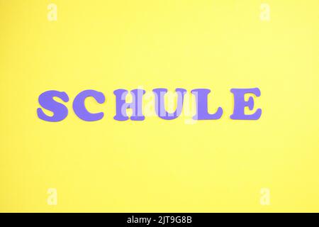 Word Schule Bedeutet Schule. Gelber Hintergrund, violette Buchstaben Stockfoto