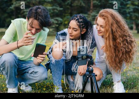 Anfänger-Blogger, die im Internet suchen, wie man ein Video schießt, das mehr Anhänger anzieht. Konzept von Jugend, Technik, Gesellschaft und Freundschaft. Gruppe Stockfoto