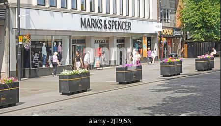 Marks und Spencer Einzelhandel Geschäft & bunte Sommerblumen in rechteckigen Blumenkästen in der Einkaufsstraße Brentwood Essex England UK Stockfoto