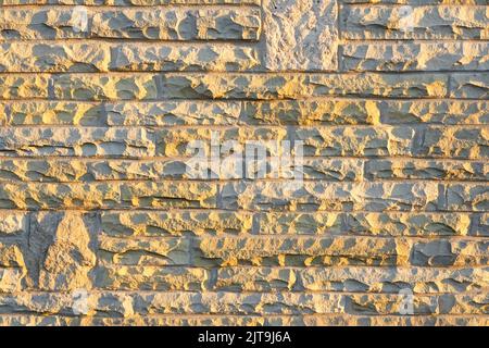 Sonnenschein auf natürlichen York-Steinblöcken, die aus redundanten Londoner Pflasterplatten geschnitten und gekleidet wurden, die in der Außenhaut der Hauswand Essex England UK wiederverwendet wurden Stockfoto