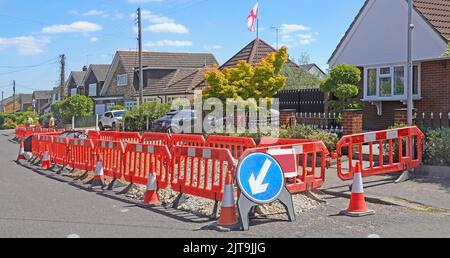 Ländliche Breitbandinfrastruktur Straßenarbeiten temporäre Straßenschild Kegel & Verriegelung rote Kunststoff-Sicherheitsbarriere in Dorf Lage Essex England Großbritannien Stockfoto