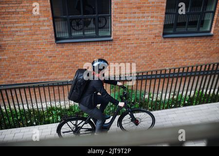 Geschäftsfrau pendeln auf dem Weg zur Arbeit auf dem Fahrrad, nachhaltiges Lifestyle-Konzept. High-Angle-Ansicht. Stockfoto