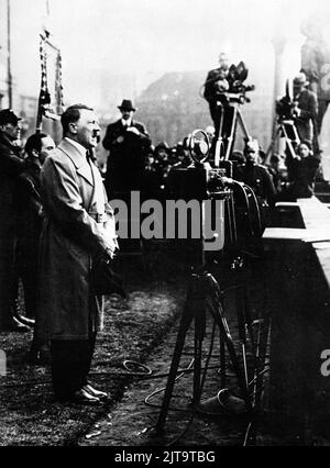 Ein Vintage-Foto um 1933, das den deutschen Nazi-Diktator Adolf Hitler zeigt, der sich während einer Wahlkampfveranstaltung an Menschenmengen wendet Stockfoto