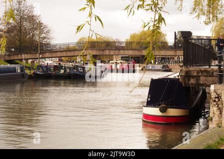 Eine Ansicht von Lastkähne im Kanalbecken bei Ely, Cambridgshire, England, zeigt eine Fuß- und Straßenbrücke, die über die Brücke führt Stockfoto