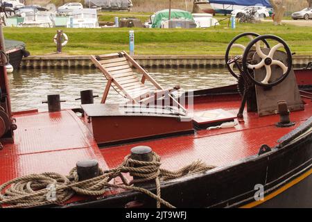 Eine Teilansicht einer festgetäuten Barge im Kanalbecken bei Ely, Cambridgeshire, England, mit Seilen, Rumpf und Deck Stockfoto