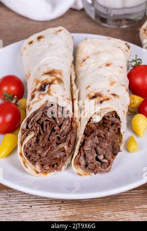 Döner Kebab Einwickeln. Fleisch Döner Kebab auf Holzhintergrund. Traditionelle türkische Küche. Nahaufnahme. Lokaler Name durum et doner Stockfoto