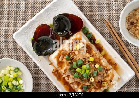 Köstliche gekühlte Tofu- und Century Egg Food mit Sojasauce und Bonito-Flocken in Taiwan. Stockfoto