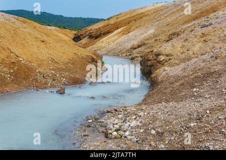 Heißer Schwefelwasserstoff-Strom zwischen den Ufern von Vulkanasche und Tephra in der Caldera des Vulkans Golovnin, Insel Kunashir Stockfoto