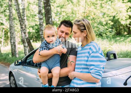 Mama, Papa und kleiner Sohn in einem Cabriolet. Sommer Familienausflug in die Natur Stockfoto