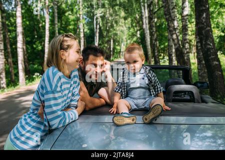 Mama, Papa und kleiner Sohn in einem Cabriolet. Sommer Familienausflug in die Natur Stockfoto