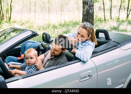 Mama, Papa und kleiner Sohn in einem Cabriolet. Sommer Familienausflug in die Natur Stockfoto