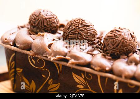 Kuchen namens Brigadeiro Caseirhiro. Schokoladenkuchen mit Schokoladenfrosting und Brigadierern zum Dekorieren. Süßwaren, Dessert. Stockfoto