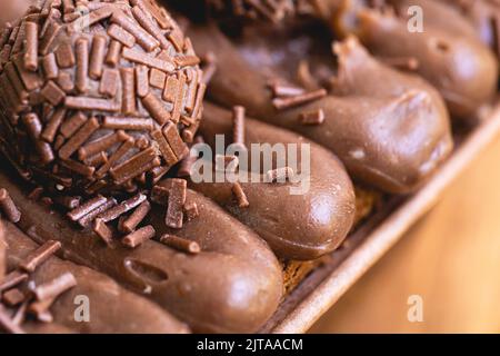 Kuchen namens Brigadeiro Caseirhiro. Schokoladenkuchen mit Schokoladenfrosting und Brigadierern zum Dekorieren. Süßwaren, Dessert. Stockfoto