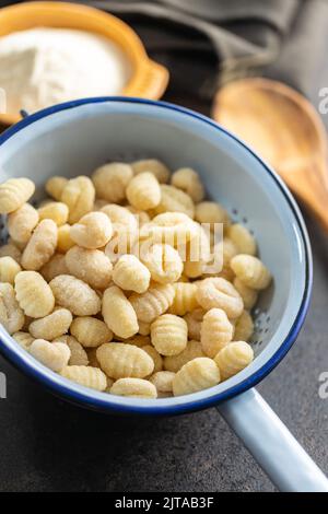 Ungekochte Kartoffelgnocchi in einem Sieb. Leckeres italienisches Essen. Stockfoto