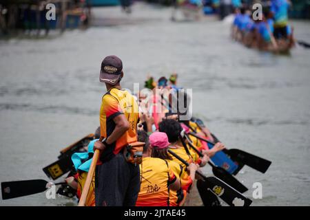 Eine Nahaufnahme von Menschen, die auf einem Boot beim Drachenbootfest in Tai O, Hongkong, paddeln Stockfoto