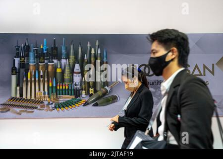 Pak Kret, Nonthaburi, Thailand. 29. August 2022. Die Expo-Teilnehmer kommen am ersten Tag der Ausstellung „Verteidigung und Sicherheit 2022“ in Thailand an einer Werbeplakierung für explosive Artilleriesullen und -Munitionsgranaten vorbei. Die Konferenz fand im Massive Impact Convention Center in der Provinz Nonthaburi neben der Hauptstadt Bangkok statt und zog Vertreter der Militärs zahlreicher Nationen an, um sich mit Verteidigern aus der ganzen Welt zu treffen. (Bild: © Adryel Talamantes/ZUMA Press Wire) Stockfoto