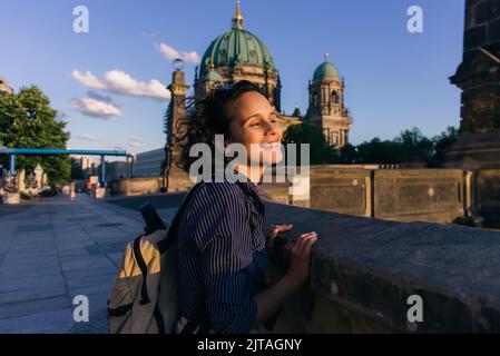 BERLIN, DEUTSCHLAND - 14. JULI 2020: Fröhliche junge Frau in der Nähe des verschwommenen berliner Doms, Stockbild Stockfoto