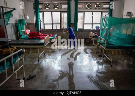 Kathmandu, Nepal. 29. August 2022. Eine Krankenschwester reinigt eine Station mit Patienten, die mit Dengue im Sudraraj Tropical and Infectious Disease Hospital in Kathmandu aufgenommen wurden. Der Dengue-Ausbruch hat 70 von 77 Distrikten erreicht, wobei die Gesundheitsdienste sagen, dass er 539 Patienten verzeichnet hat. Kredit: SOPA Images Limited/Alamy Live Nachrichten Stockfoto