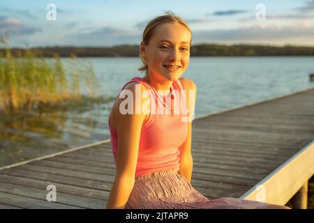 Porträt eines glücklichen lächelnden Teenagers mit Zahnspangen in einem Park. Stockfoto