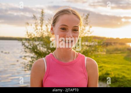 Porträt eines glücklichen lächelnden Teenagers mit Zahnspangen in einem Park. Stockfoto