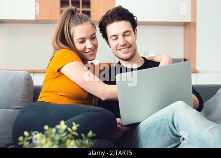 Junges Paar, das Zeit im Internet genießt und in einem Laptop sucht Stockfoto