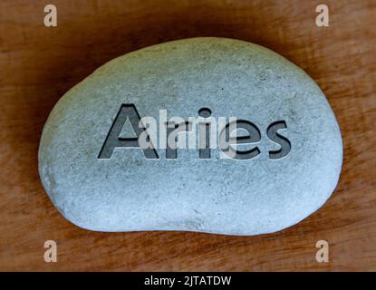 Widder Tierkreiszeichen Text auf einem Stock mit Holzhintergrund eingraviert. Sternzeichen Konzept Stockfoto