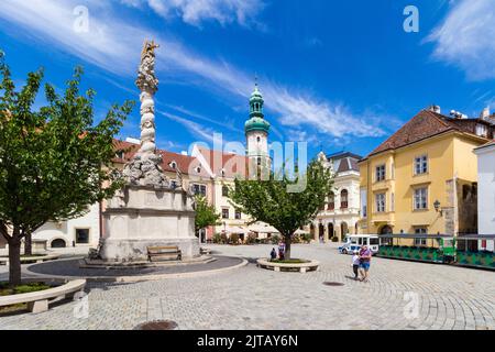 Fo ter (Hauptplatz) mit der Dreifaltigkeitsstatue (1701), Feuerwache und Touristenzug, Sopron, Ungarn Stockfoto