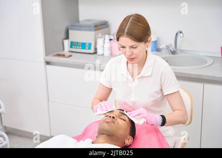Dermatologe Vorbereitung junger Mann für Schönheitsverfahren Stockfoto